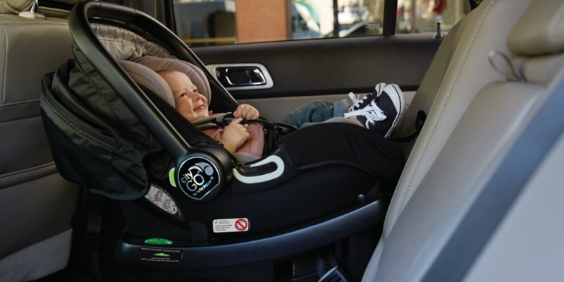 Baby girl sitting rear-facing in a Baby Jogger City GO Infant Car Seat