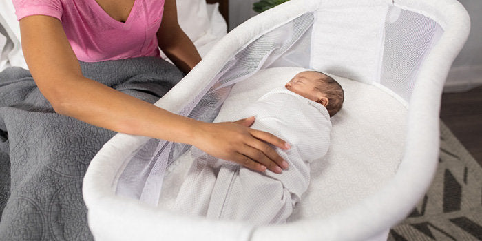 Mom putting baby to sleep in a HALO Bassinet