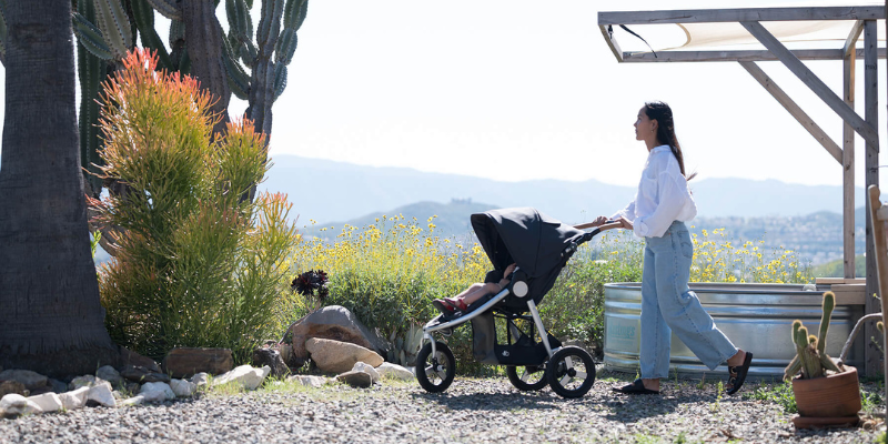 Mom pushing Bumbleride Indie Stroller outside on scenic path