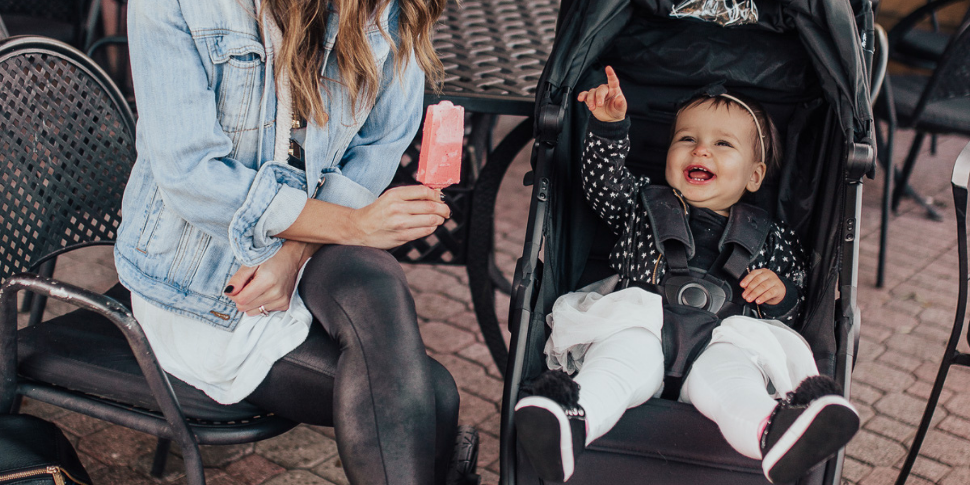 Baby smiling and pointing in a Baby Jogger Stroller