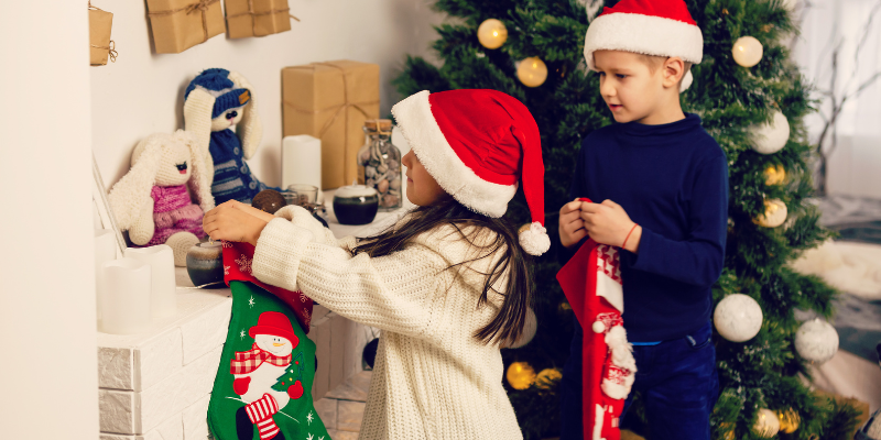 Little Girl and Little Boy Grabbing Christmas Stockings