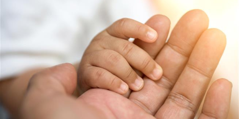 Baby holding parent hand