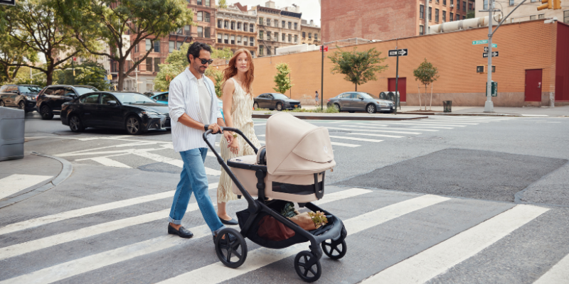Mom and dad pushing Bugaboo Kangaroo stroller across a crosswalk