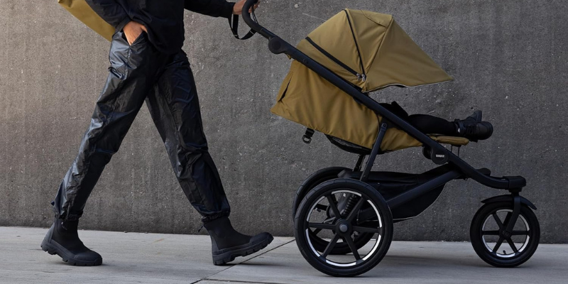 Dad pushing Thule Urban Glide 3 with seat reclined and canopy down