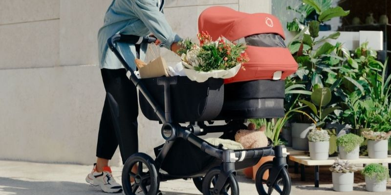 Woman Pushing Bugaboo Donkey 5 Stroller With Bassinet Attachment and Basket Attachment