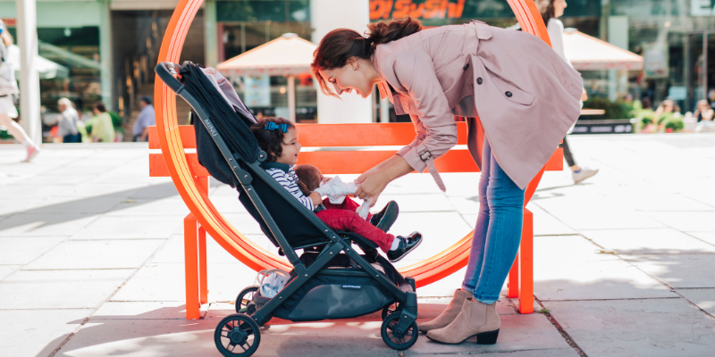 Woman Bending Over While Little Girl is Sitting in UPPAbaby Minu V2 Stroller