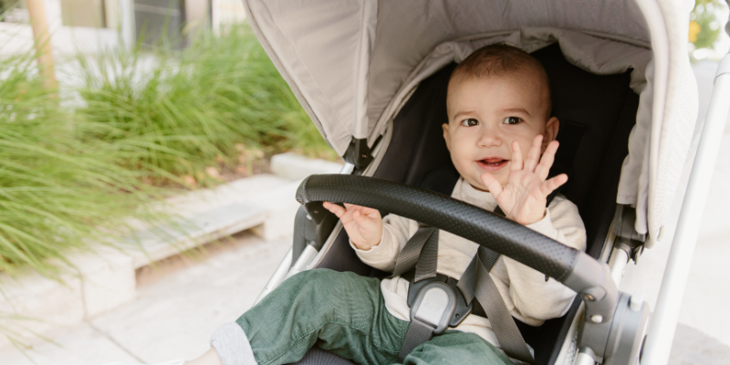 Baby waving in the UPPAbaby CRUZ V2 Stroller