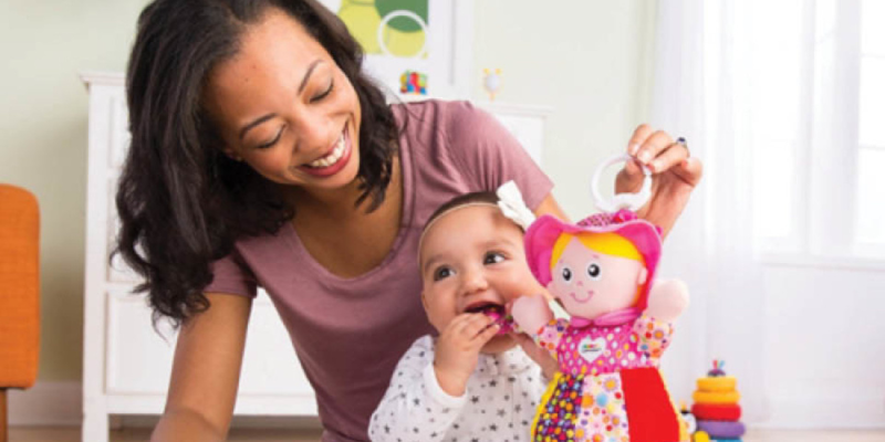 Mom playing with her baby with a doll
