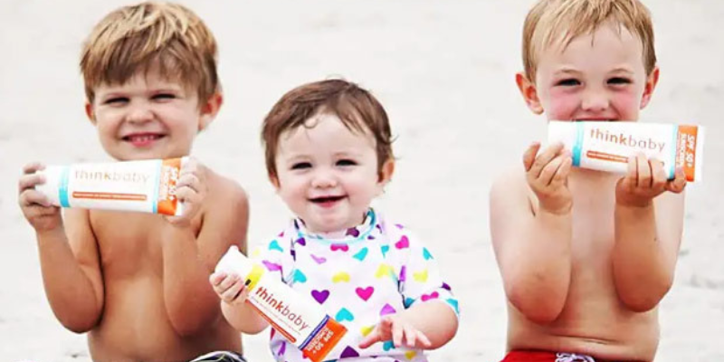 Three children holding sunscreen