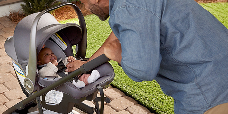 Man Looking Into Britax Willow S Infant Seat With Baby Sitting Inside