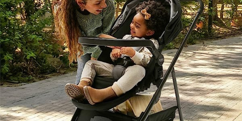 Little Girl Sitting in Willow Brook Stroller With Woman Looking at Her Smiling