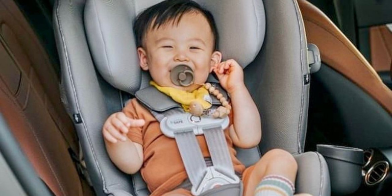 Baby smiling sitting in their Sirona S SensorSafe 360 rotating car seat