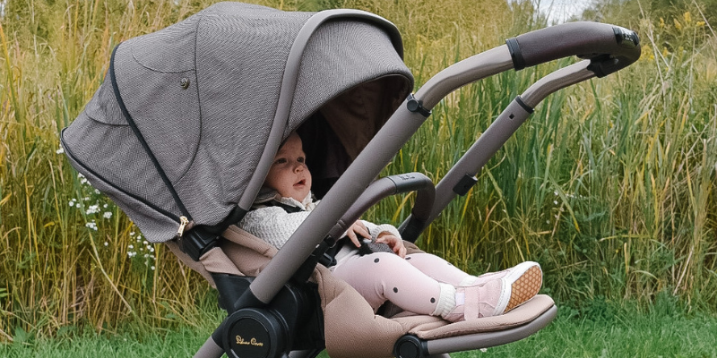 Baby girl sitting in the Silver Cross Reef Stroller on a country path
