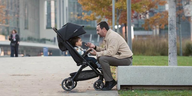 Dad sitting facing child in the Nuna TRVL LX stroller