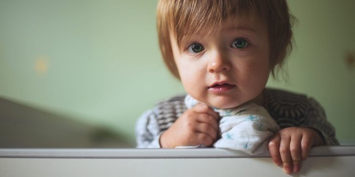 Baby peering over their crib