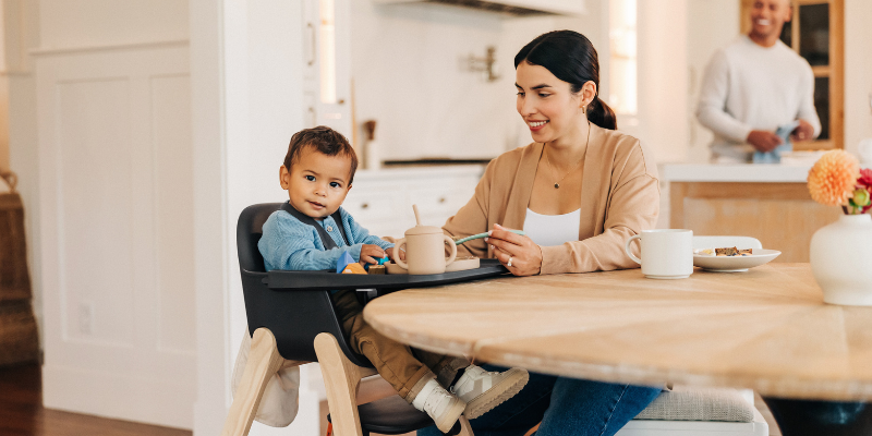 Little boy being fed by his mother in the UPPAbaby Ciro High Chair with mother.