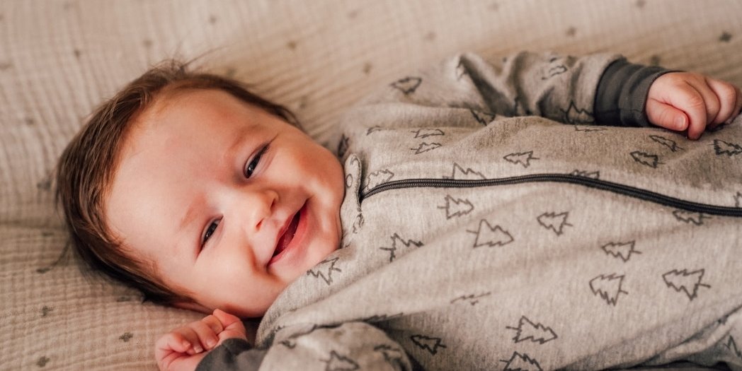 Baby smiling in bassinet