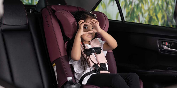 Little Girl Sitting in Diono Car Seat Making a Heart Shape out of Her Hands