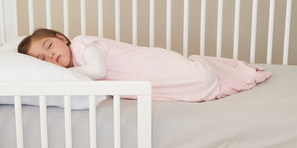 toddler sleeping in pink sleep sack
