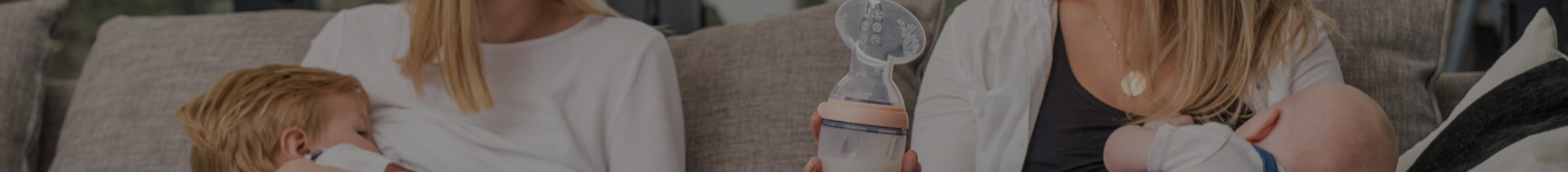 Two moms sitting on a couch nursing their children with Haakkaa breast pumps