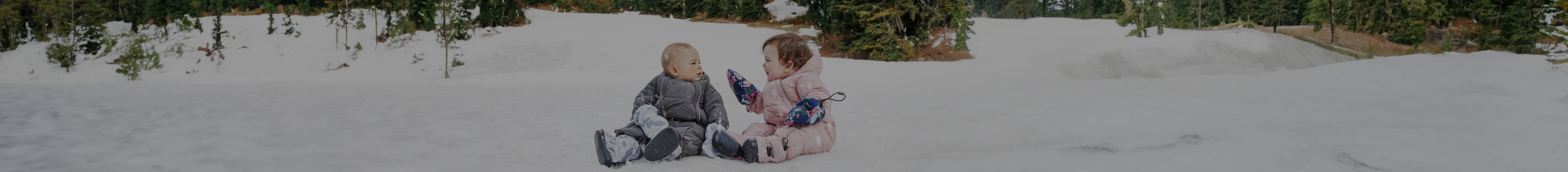 Babies dressed in Stonz Wear Inc winter snow suits and gloves on the snow