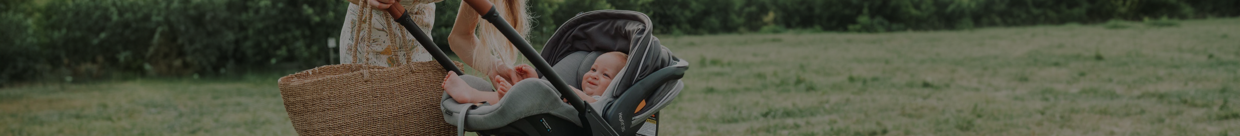 Mom in the park with her baby in a Chicco infant seat travel system