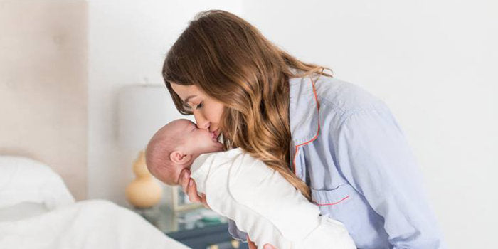 Mother kissing newborn baby