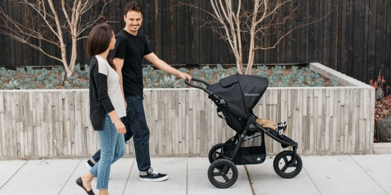 Mom and Dad walking with a Bumbleride Indie All-Terrain Stroller