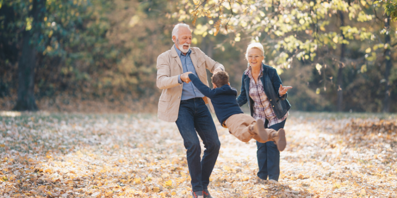 Elderly Couple Swinging Little Kid in Air