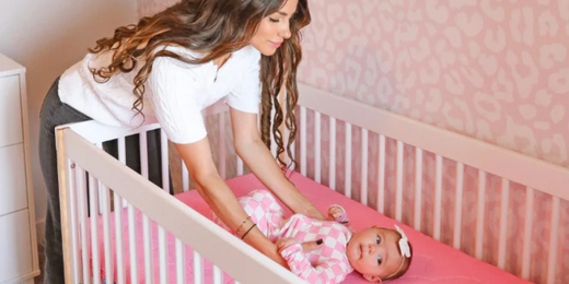 Mom laying baby down in crib