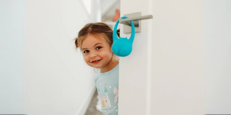 Toddler leaving her room, passing a DECCO v2 monitor hanging on the door