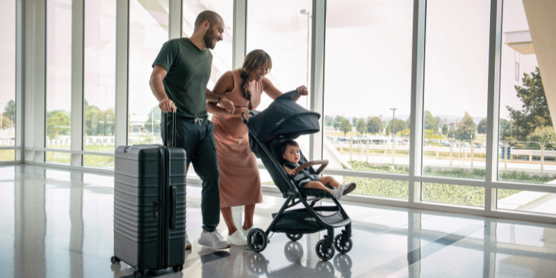 Family in airport with baby in a Nuna TRVL stroller