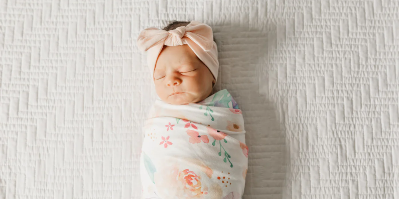 Baby swaddled in Copper and Pearl Bloom Swaddle