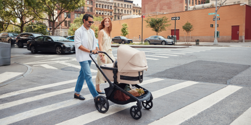 Mom and Dad pushing Bugaboo Kangaroo Stroller with bassinet attached