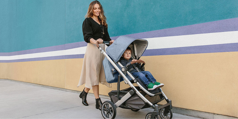 Woman Pushing UPPAbaby Cruz V2 Stroller With Toddler Sitting Inside