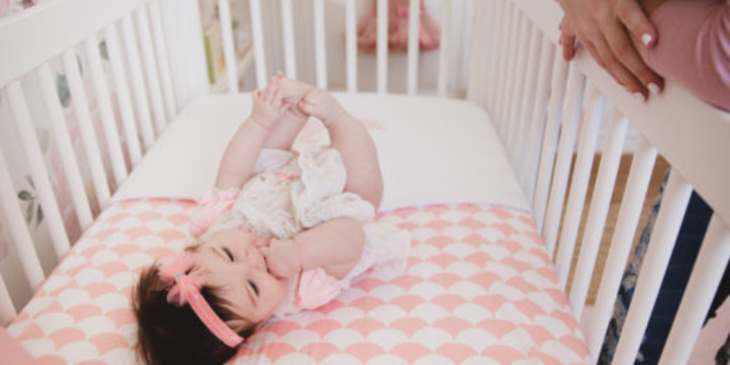  Baby Lying in Crib With Pink Checkered Sheets