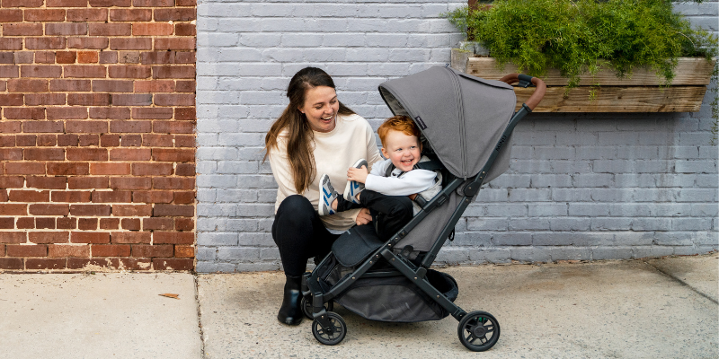 Mom kneeing by little boy in the UPPAbaby MINU V2 Stroller
