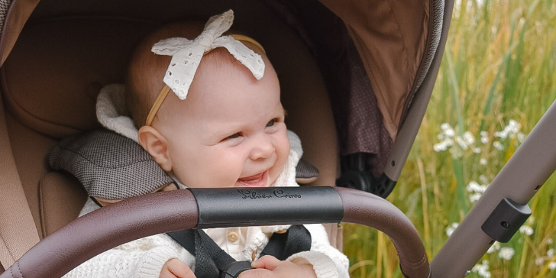 Baby girl smiling in a Silver Cross Reef Stroller