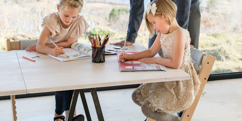 Two Girls Working at a Table Writing