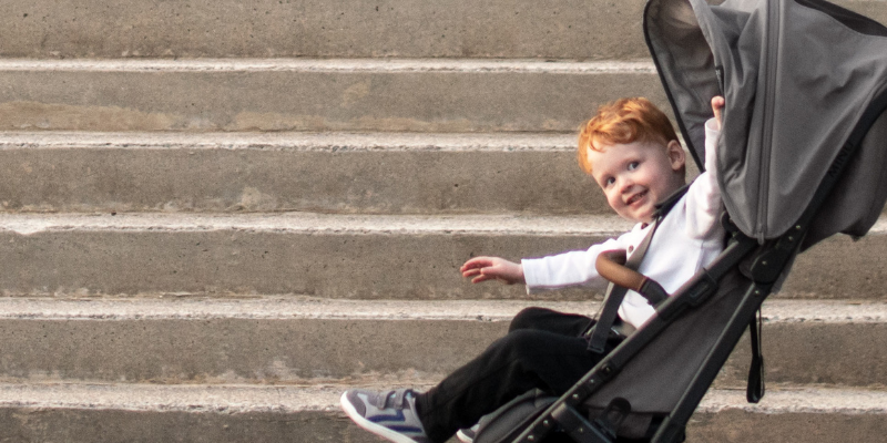 Red haired little boy smiling in an UPPAbaby MINU V2 Stroller