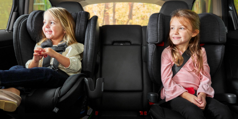 Children looking out the window smiling sitting in their UPPAbaby KNOX Convertible Seat and ALTA Booster Seat