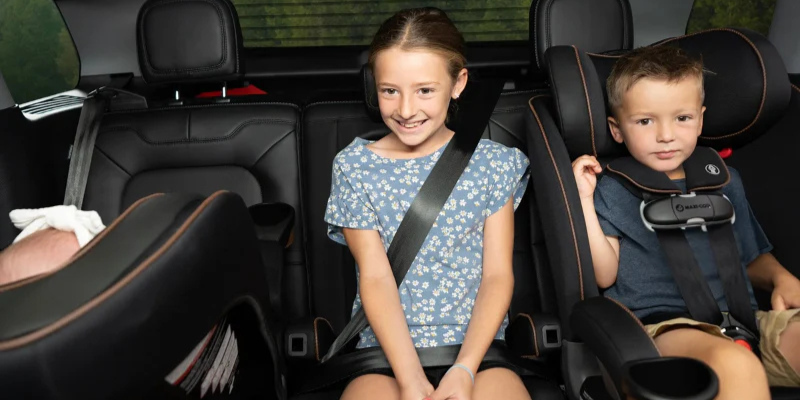 Three children sitting in the back seat in the Maxi-Cosi Kani 4-in-1 All-in-one convertible car seats in different modes