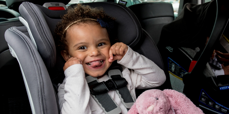 Little girl smiling in a convertible car seat