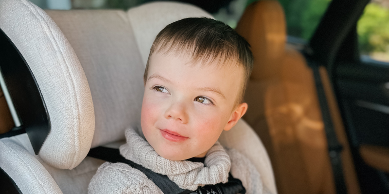 Little boy smiling in a Clek FLLO convertible car seat