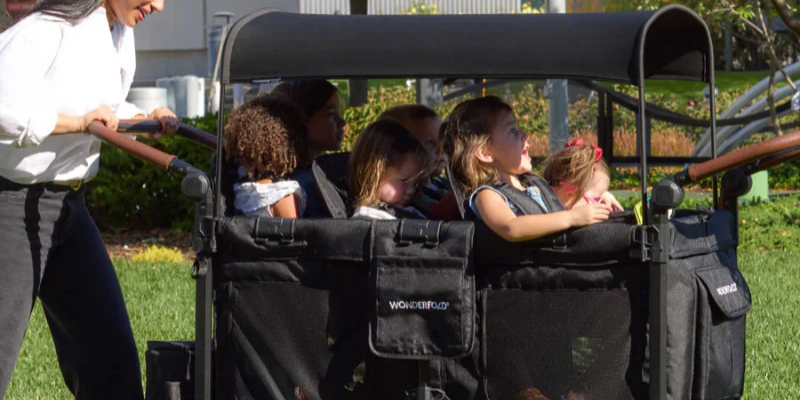 6 kids sitting in the WonderFold W6 Luxe Pro Wagon