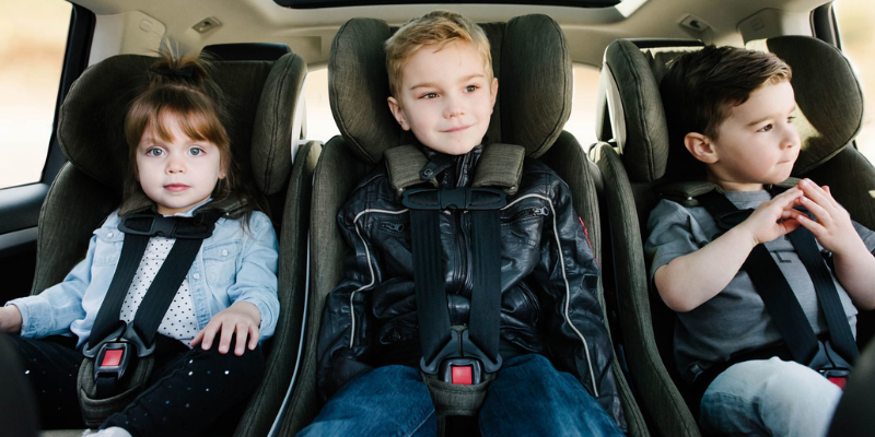 3 kids of varying ages sitting in car seats