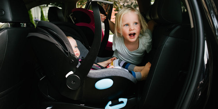 baby in car seat and toddler in back seat