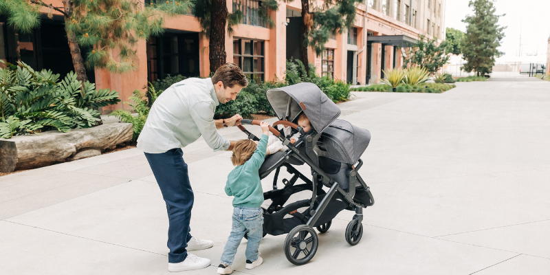 Dad pushing children in UPPAbaby Vista 3 Stroller