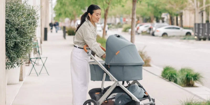 Mom pushing UPPAbaby Vista V3 Stroller with V3 Bassinet attached