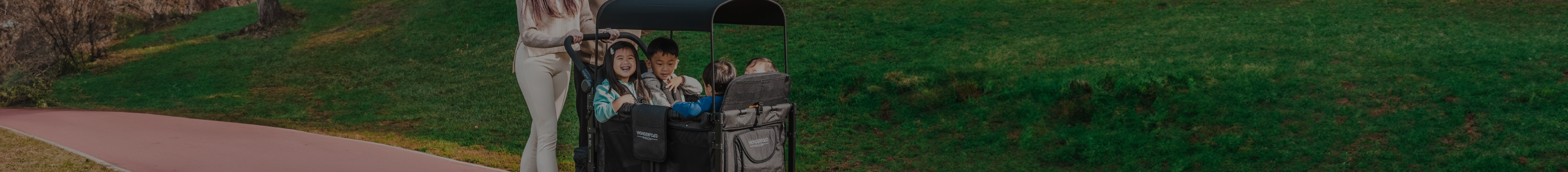 Parent pushing 4 kids in a Wonderfold all-terrain wagon